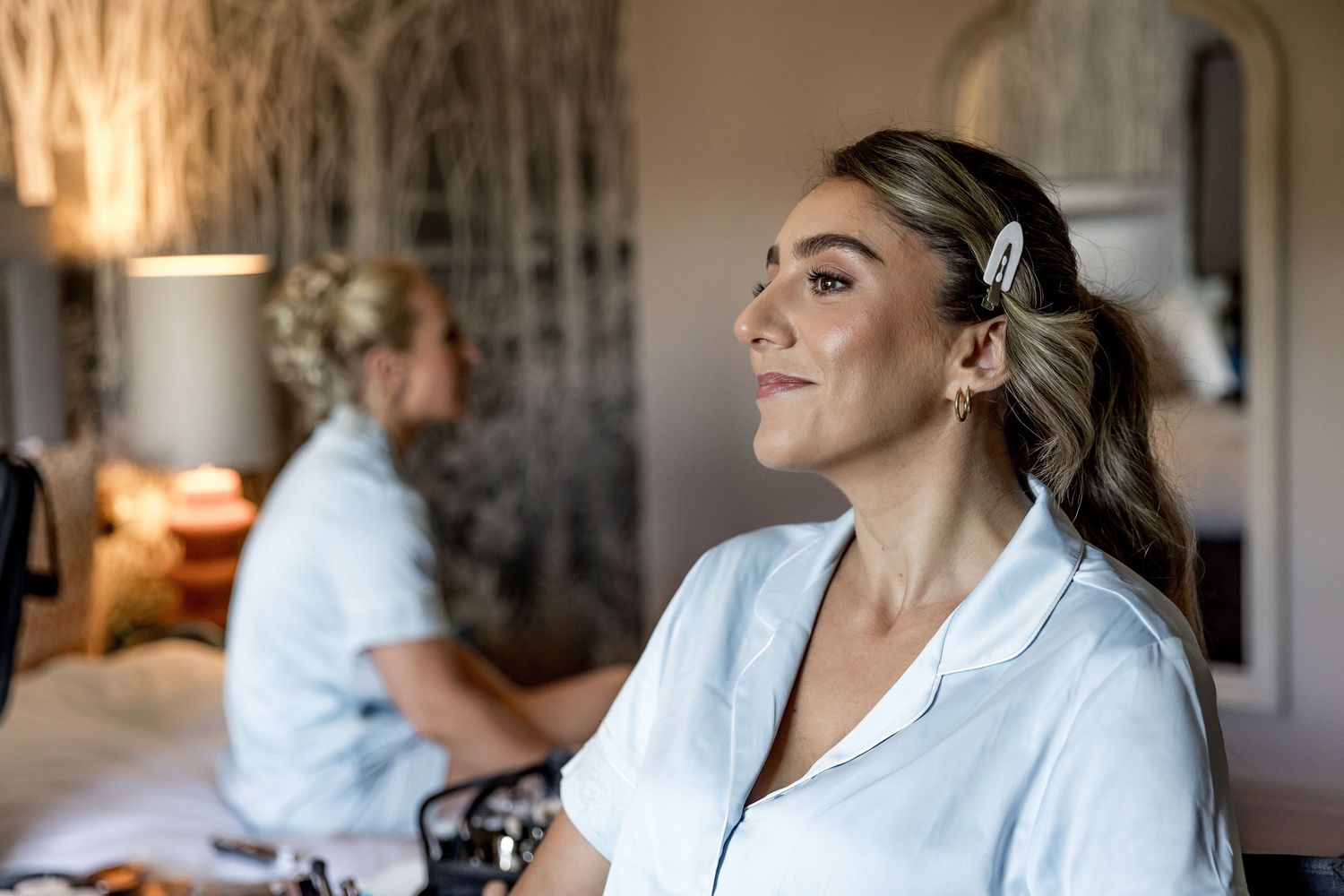 Candid moments of wedding preparation showing laughter and excitement in white robes.