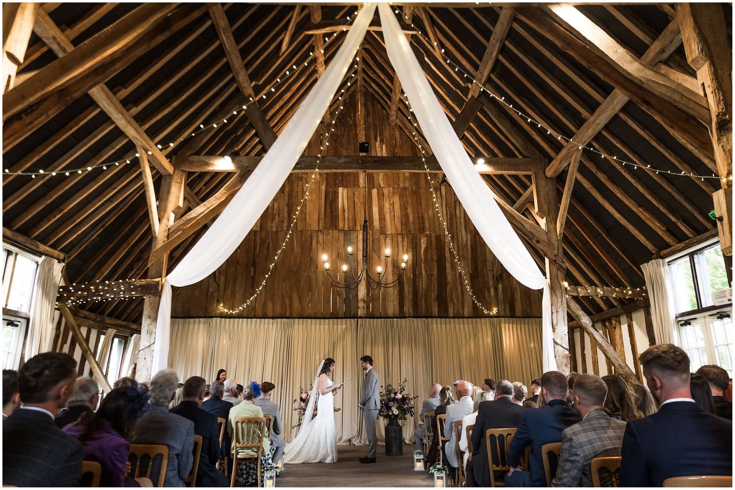 Photograph showing the full interior of Clock Barn wedding venue in Hampshire during a marriage service