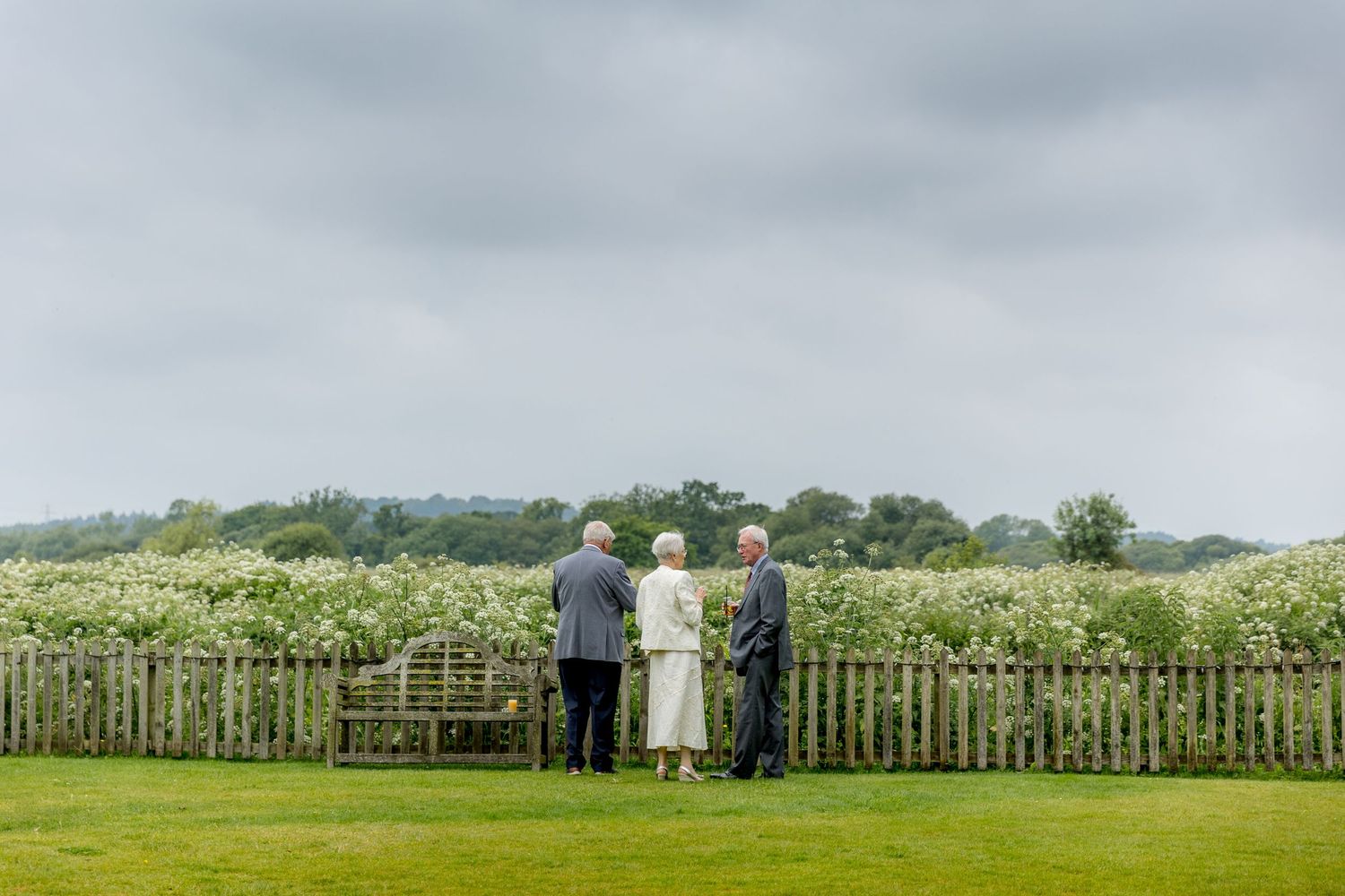 Panoramic view of a green countryside wedding venue with wooden fencing.