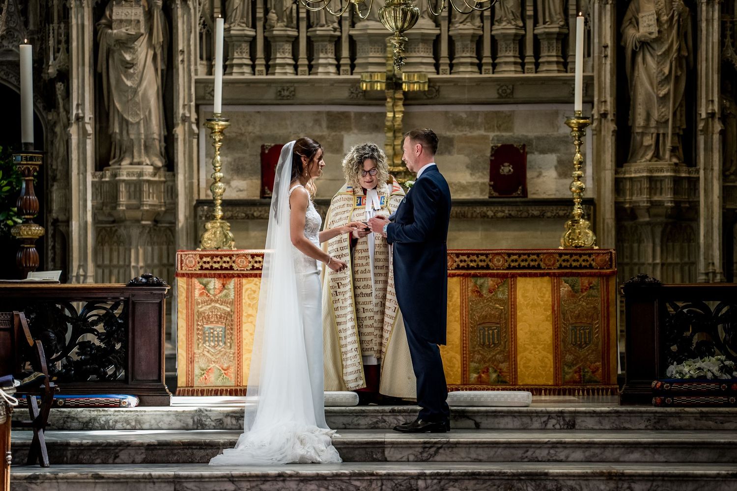 Wedding ceremony in progress inside a grand gothic cathedral with vaulted ceilings.