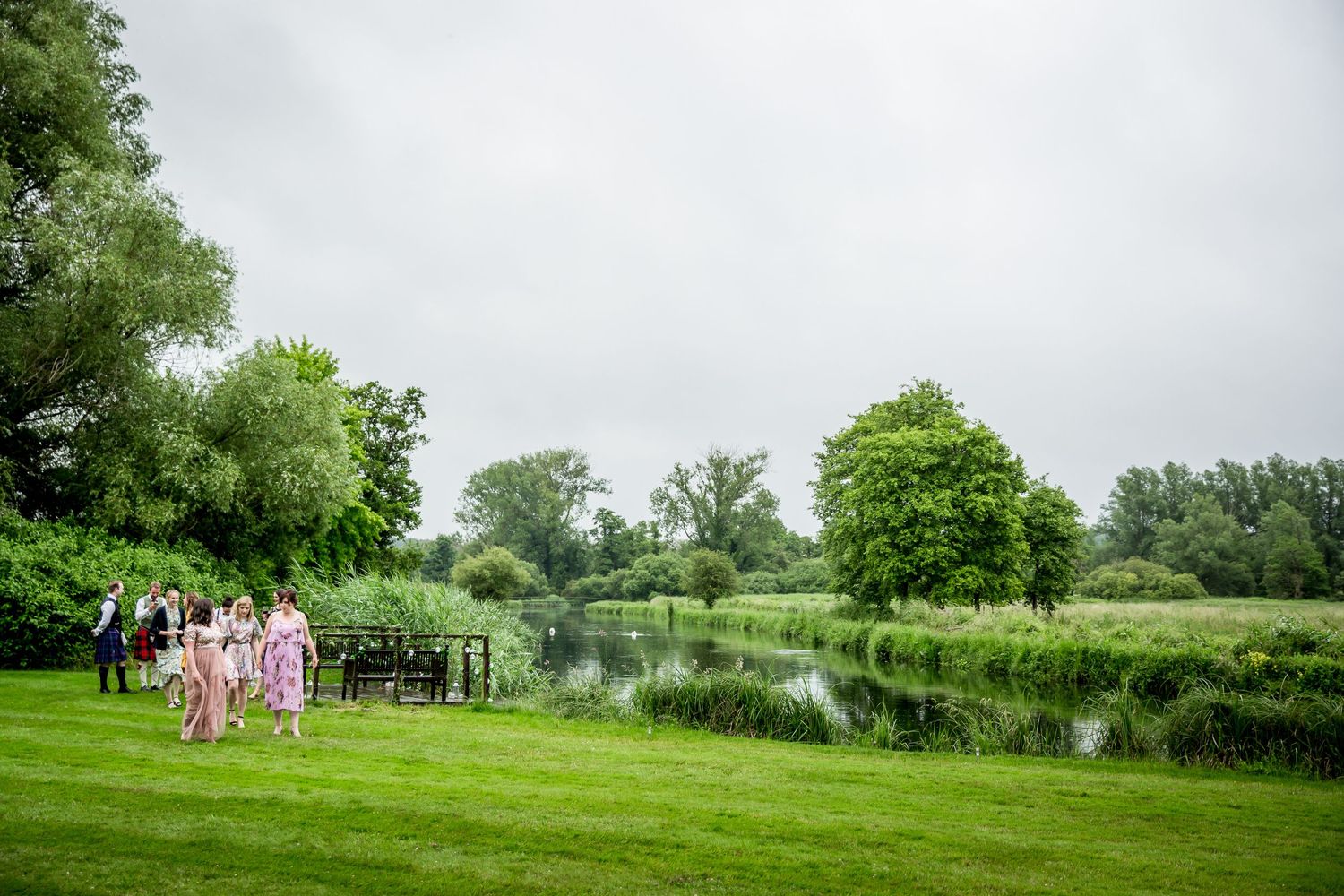 Wedding guests on the lawns outside the reception marquee at Houghton Lodge, Hampshire wedding venue near Stockbridge