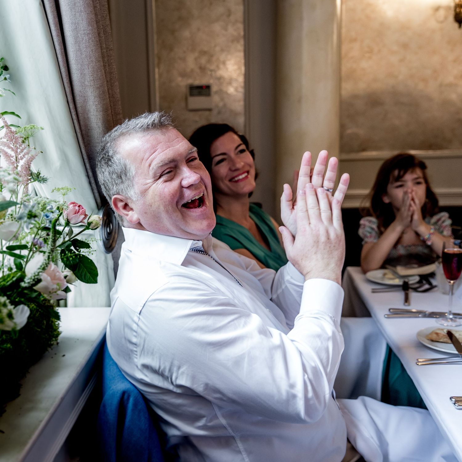 Candid reactions of guests during emotional wedding speeches at an indoor reception.