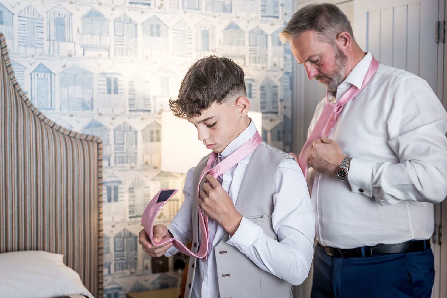 People helping with formal attire preparations before an event.
