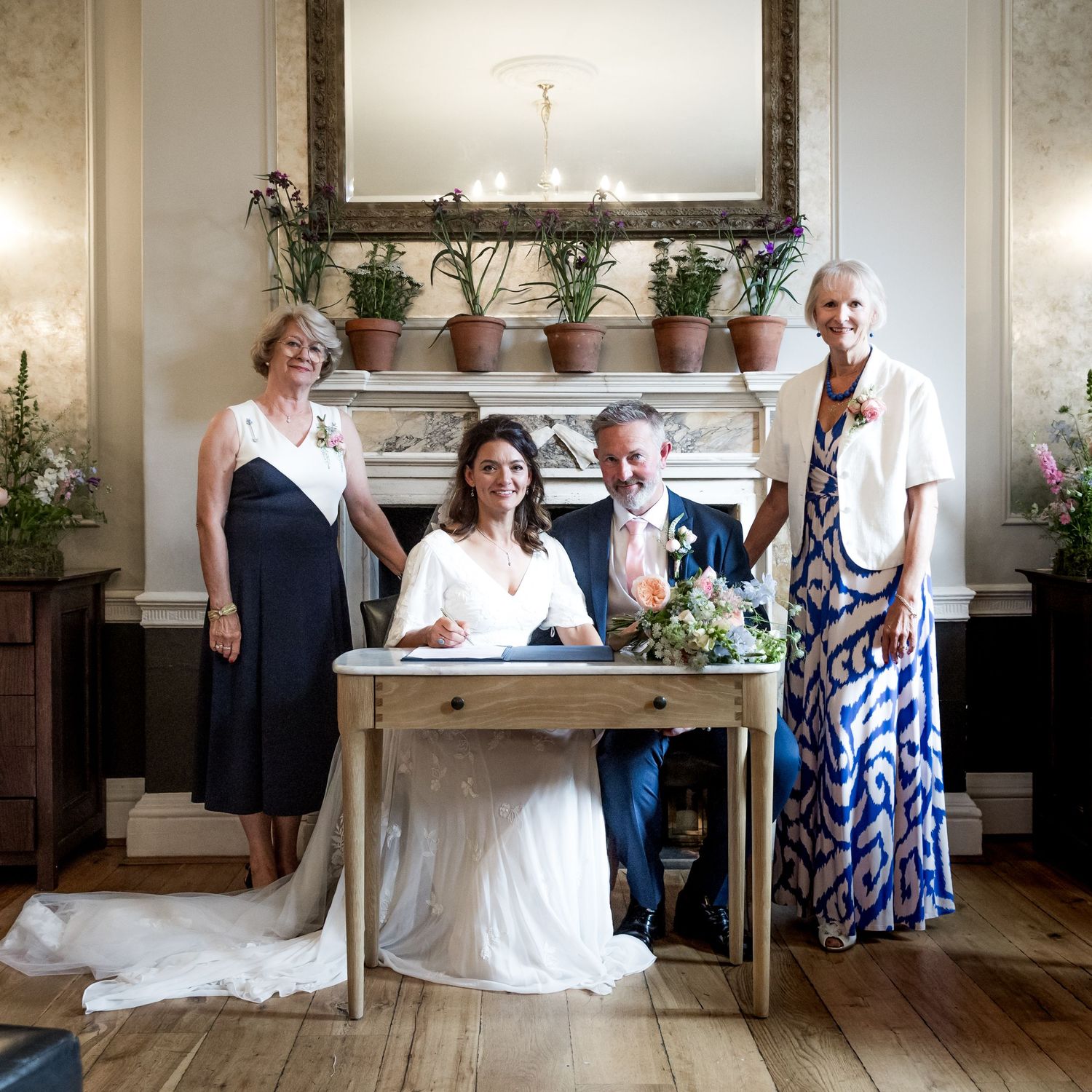 Wedding party members seated at a formal table during marriage registration.