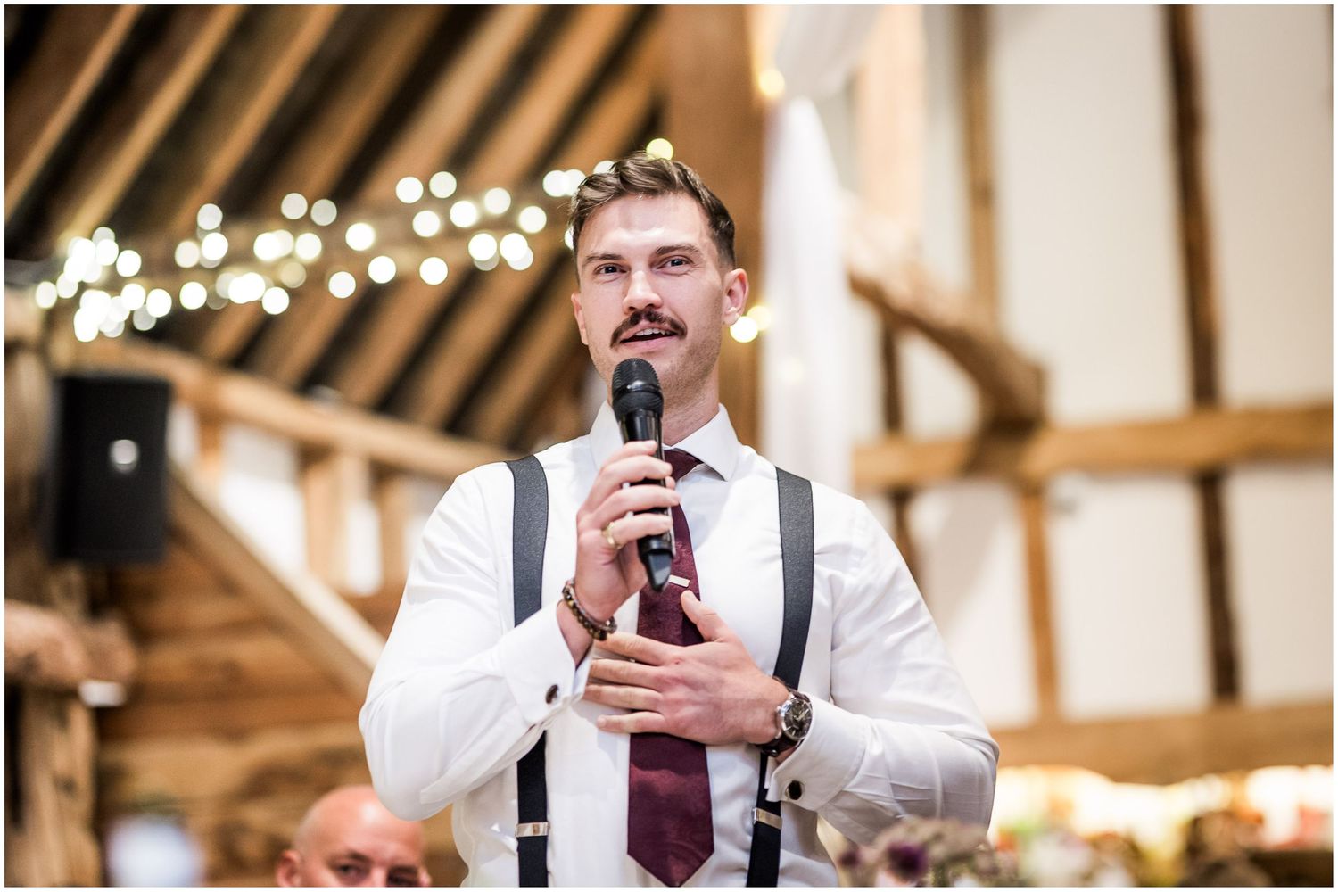 The MC at a wedding stands to introduce the wedding speeches