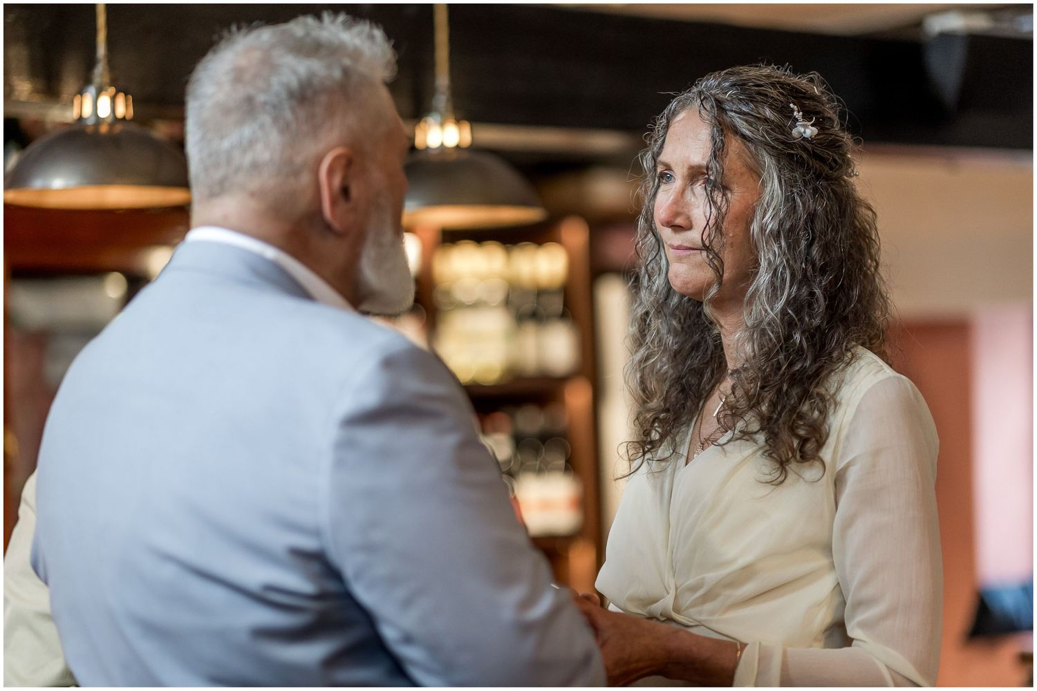 Bride and groom face each other during a marriage ceremony at Abbey Mill in Winchester.