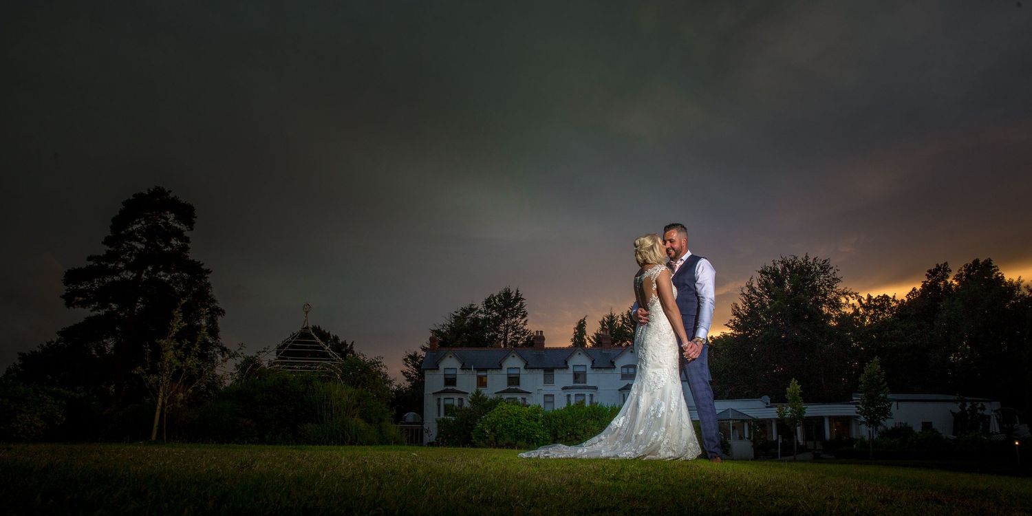 Dramatic sunset silhouette of wedding venue with evening sky.