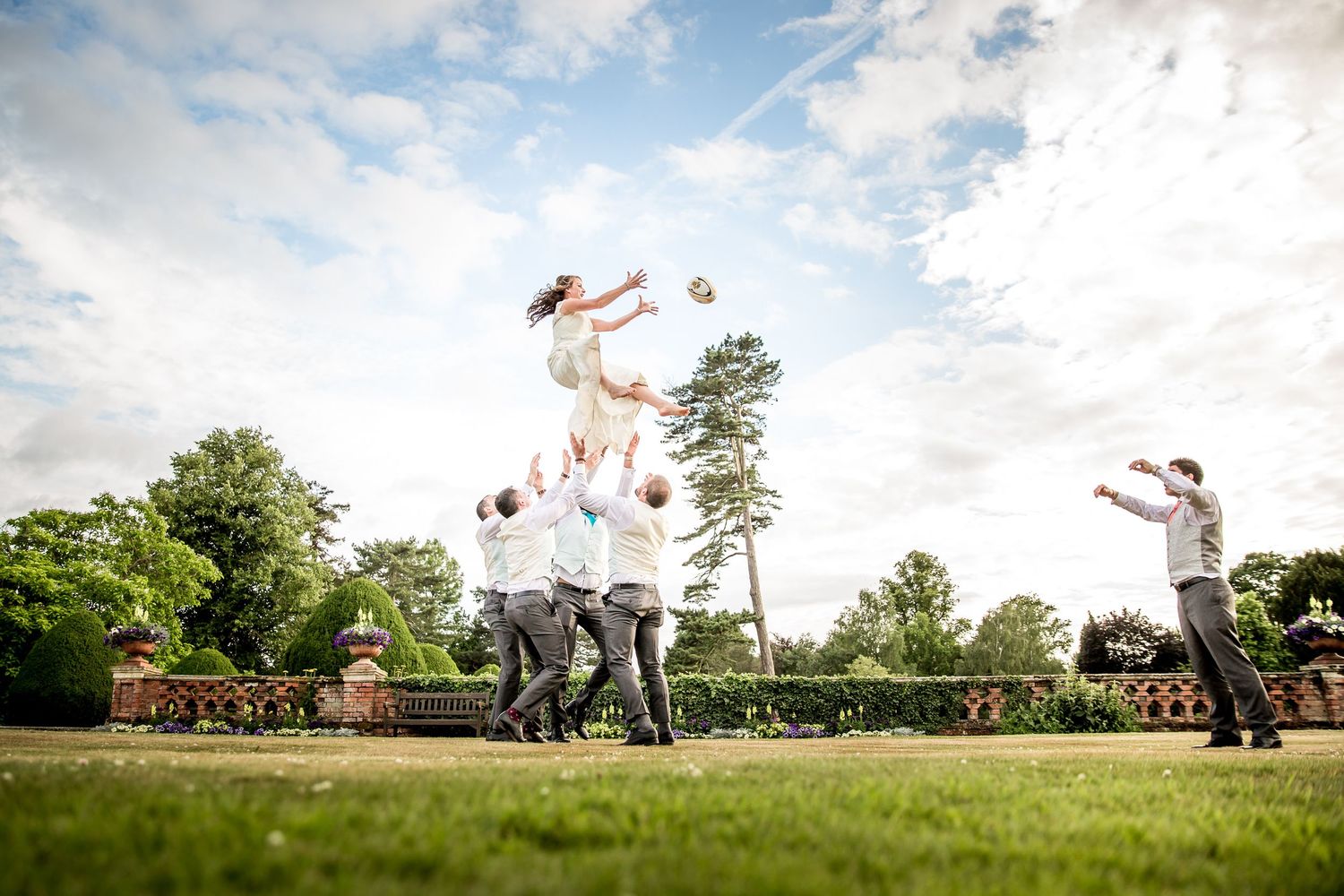 A fun wedding photo at The Elvetham Hotel with a rugby playing bride in a line-out