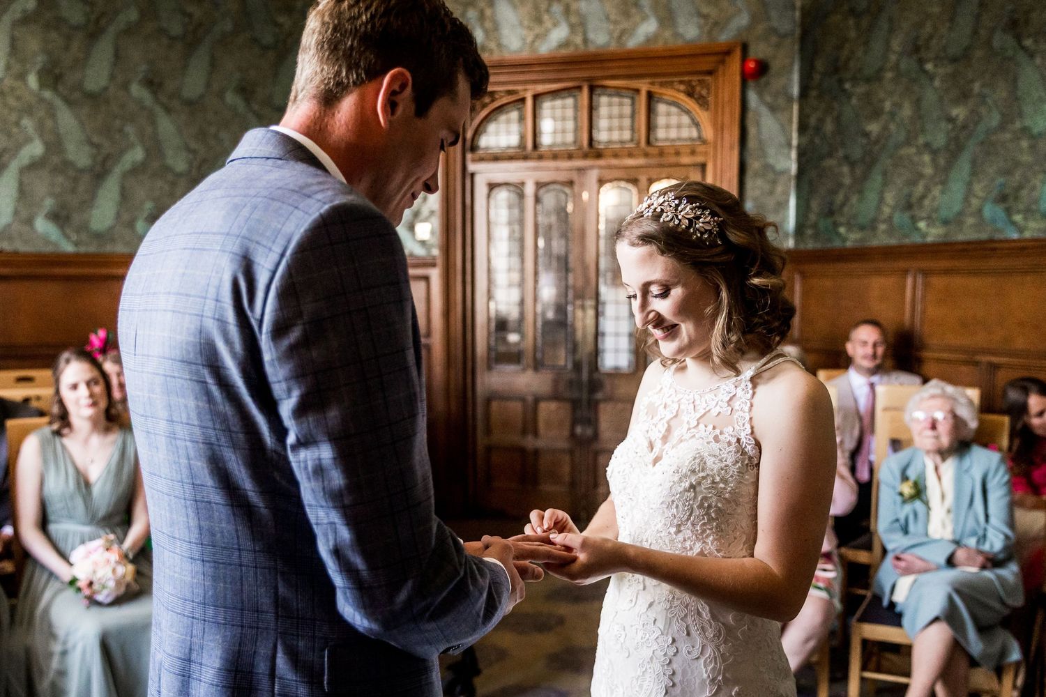 Intimate wedding ceremony moments in a historic room with decorative wallpaper.