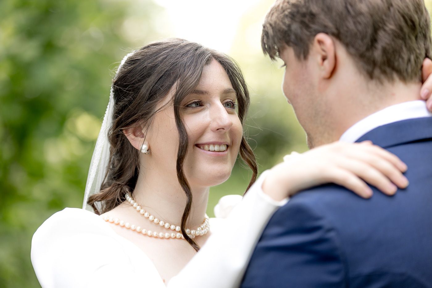 Romantic outdoor wedding photos captured in a garden setting with natural lighting and greenery.