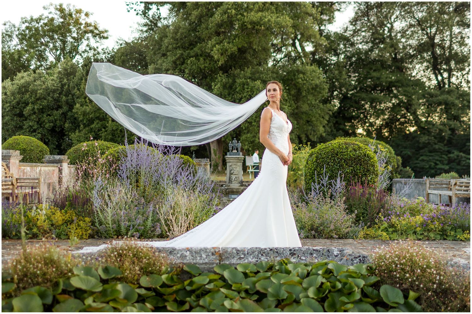 Bride in white gown with flowing veil in the garden at Walhampton School