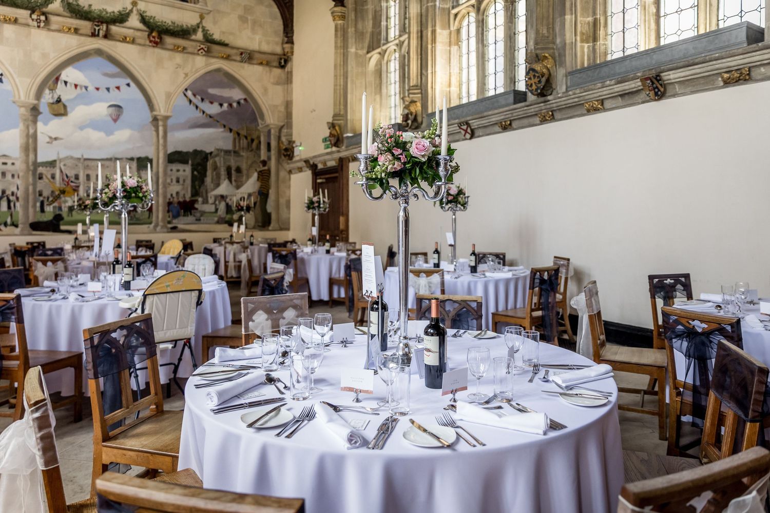 Elegant wedding reception hall set with round tables and white linens.