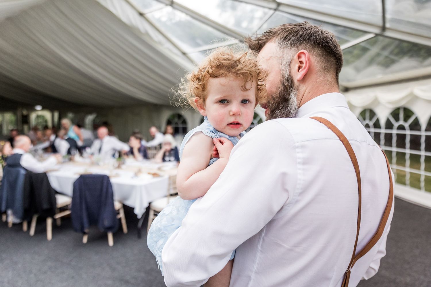 Reception celebrations under white marquee tent with dancing and festivities.