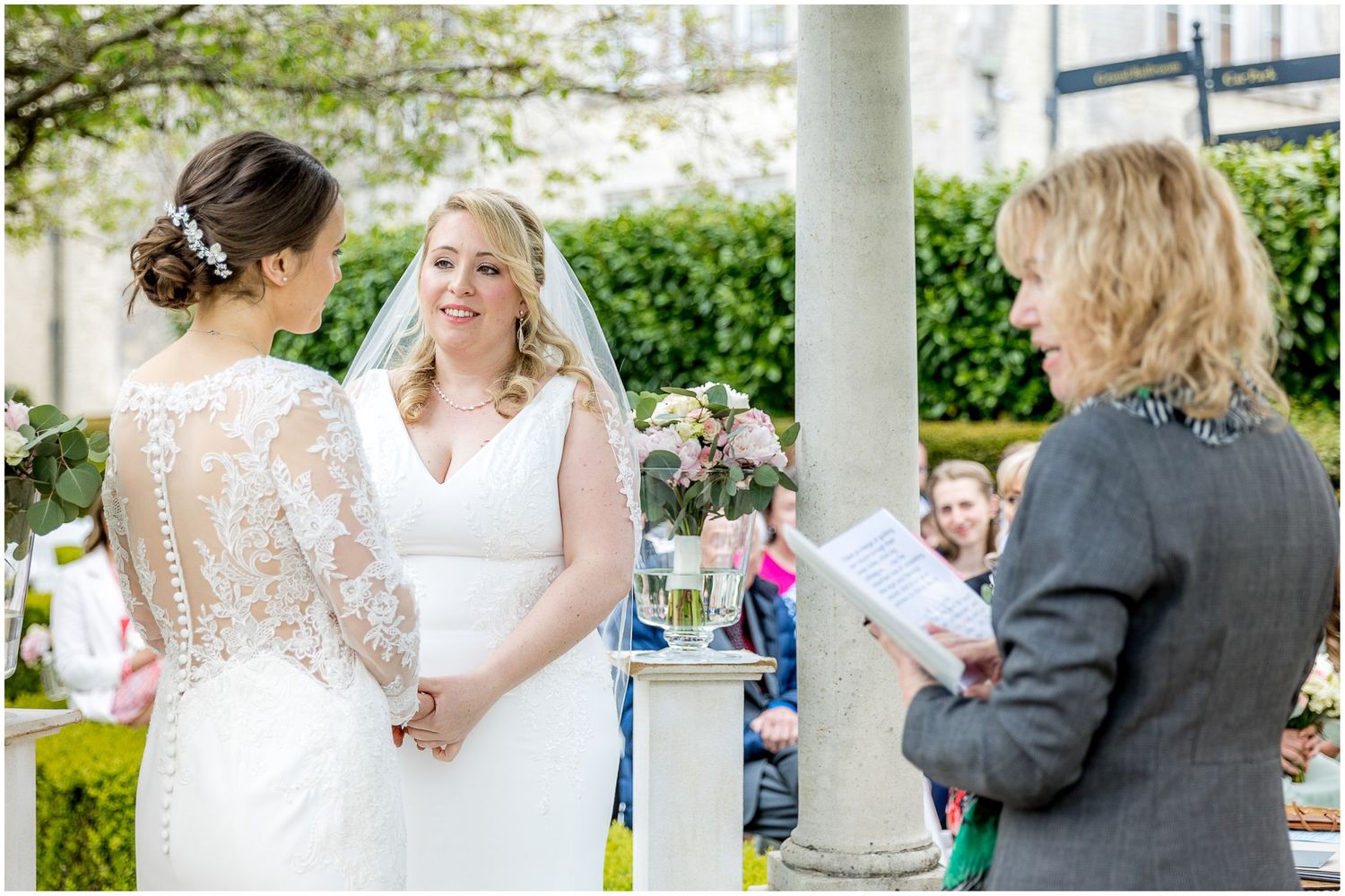 Intimate wedding moments shared under white columns during an elegant outdoor ceremony.