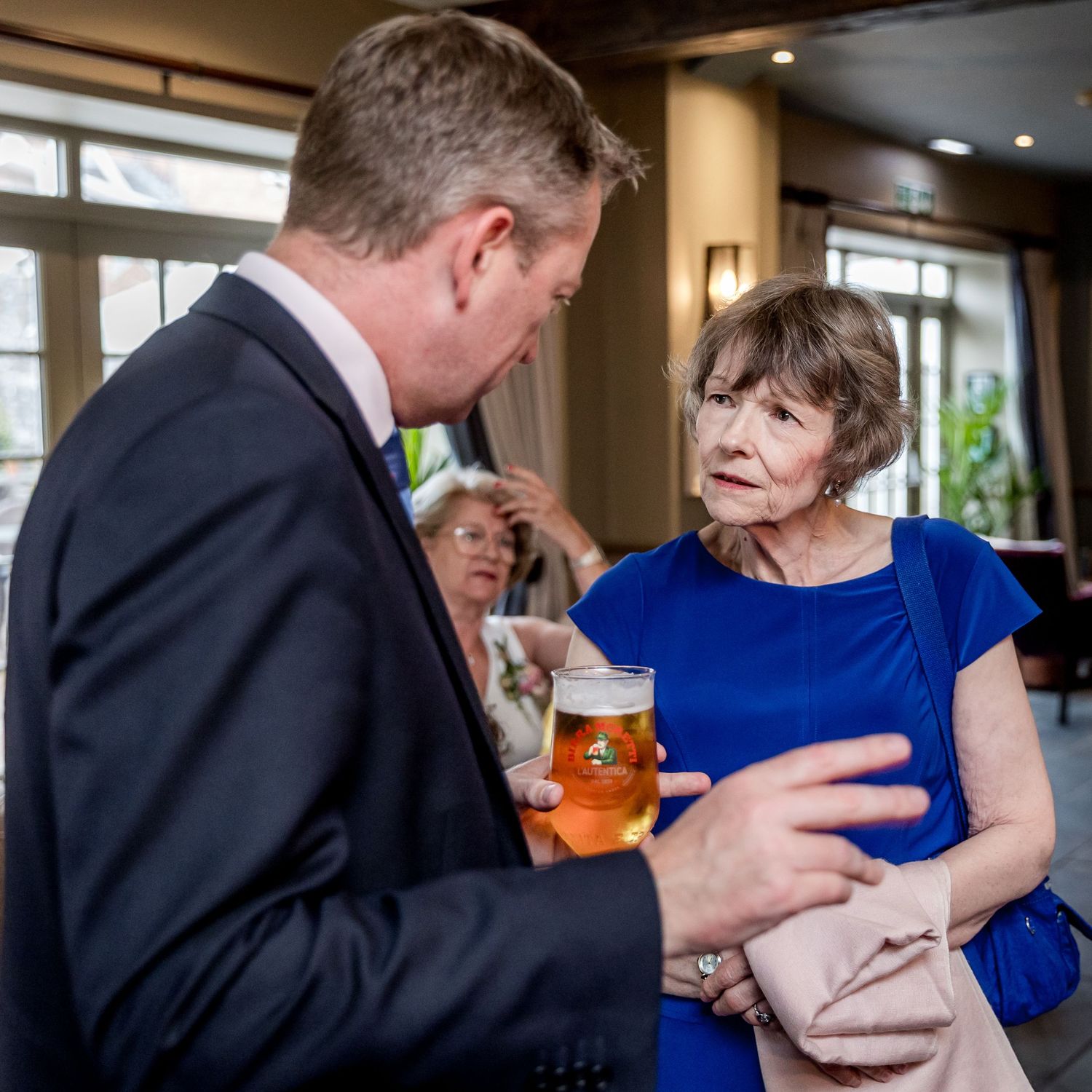 Guests mingling during a formal event in an upscale venue with warm lighting.