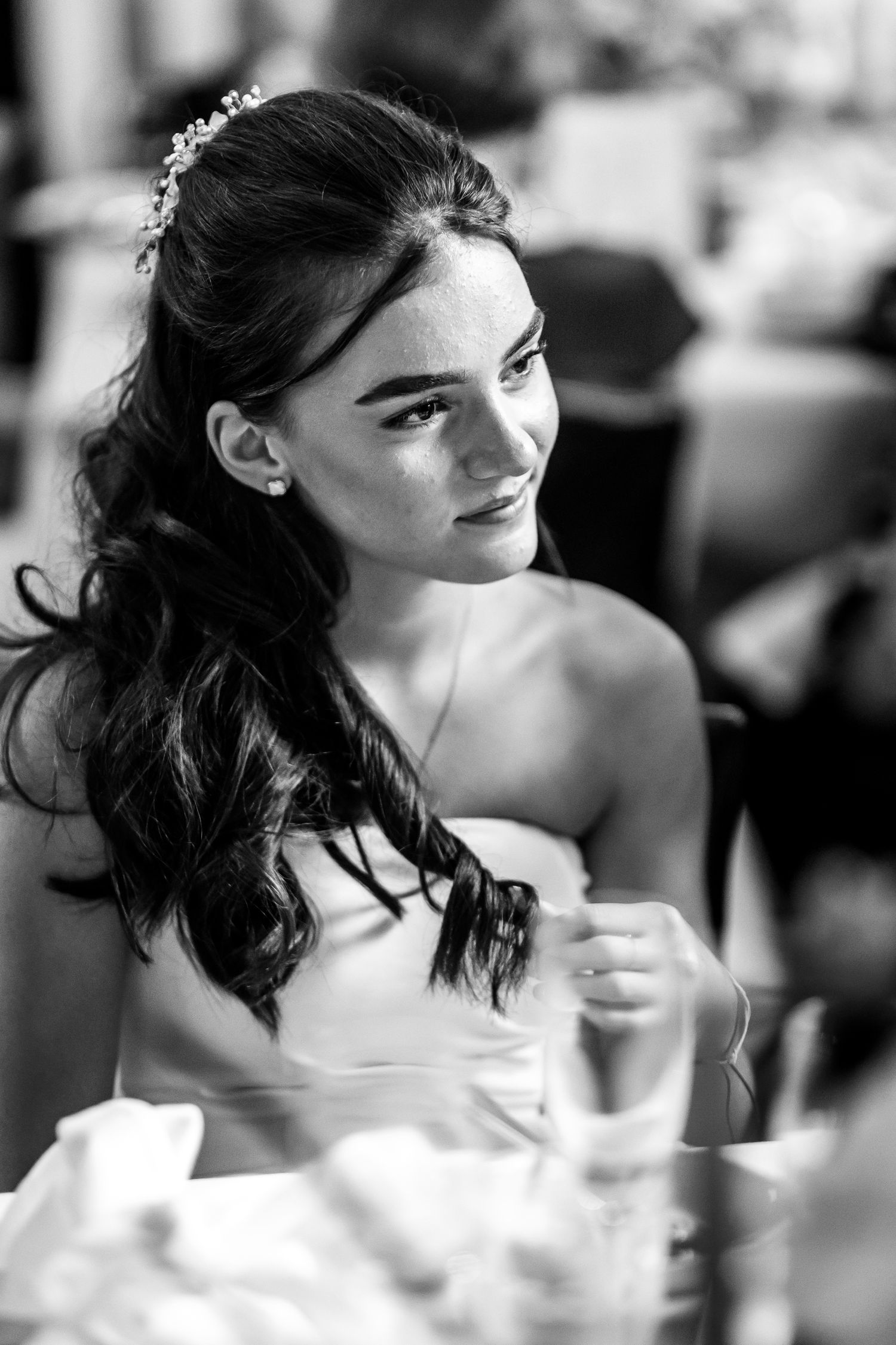 Candid black and white portraits capture expressions of happiness during a wedding reception.
