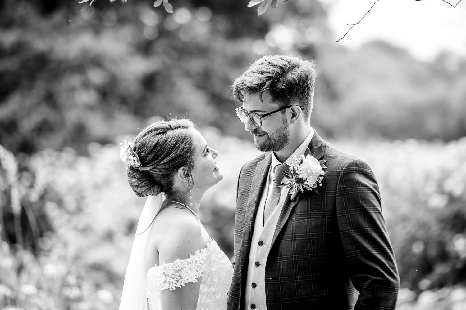 Black and white romantic wedding portraits captured in natural outdoor setting.