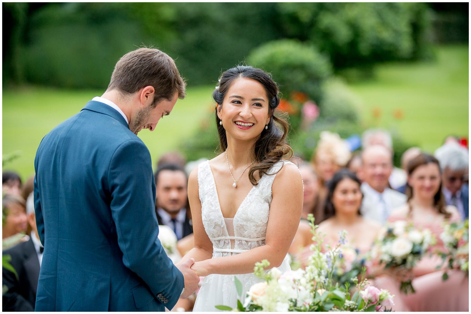 Wedding guests seated in rows during an outdoor garden ceremony.