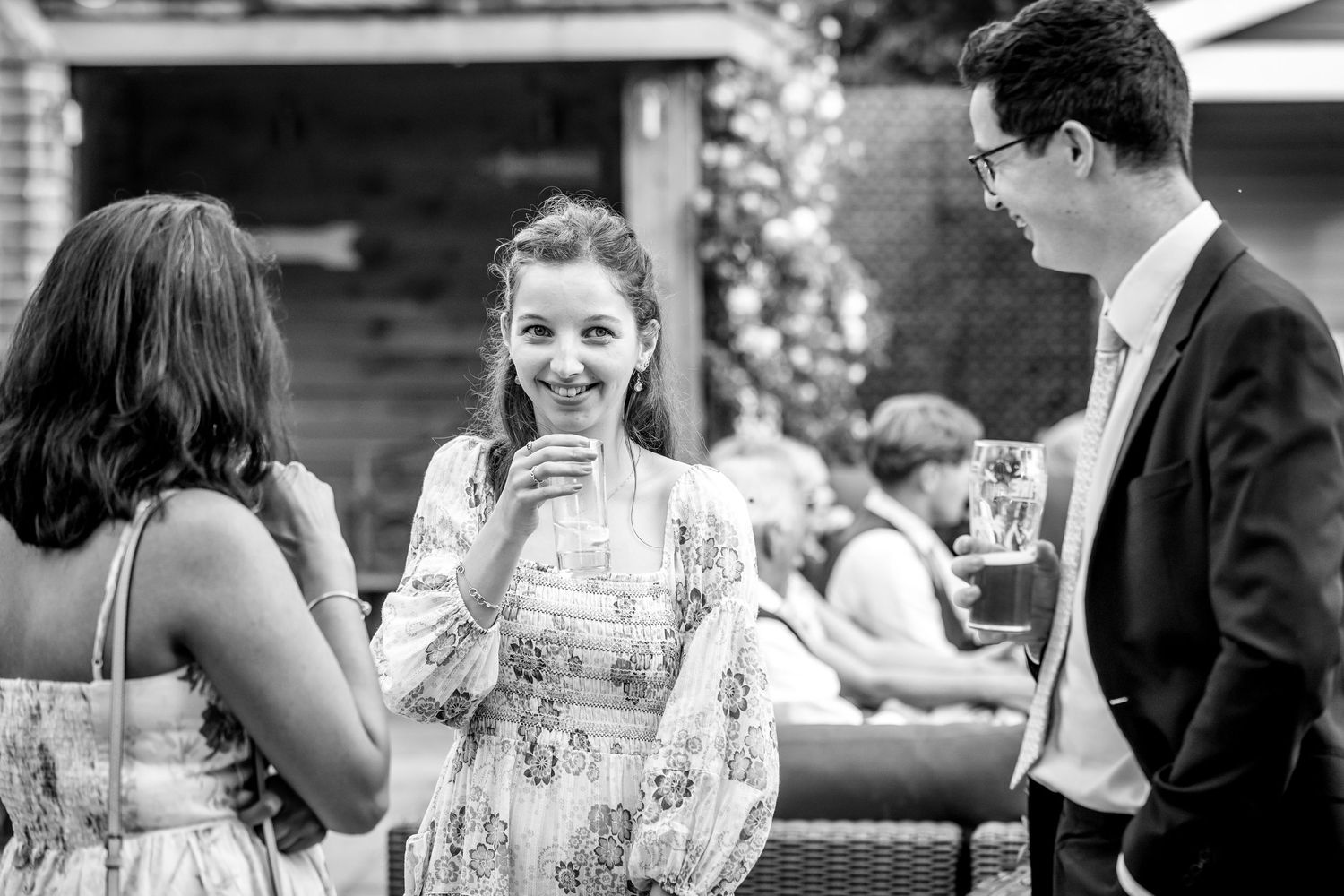 Black and white candid shots of wedding reception guests socializing.