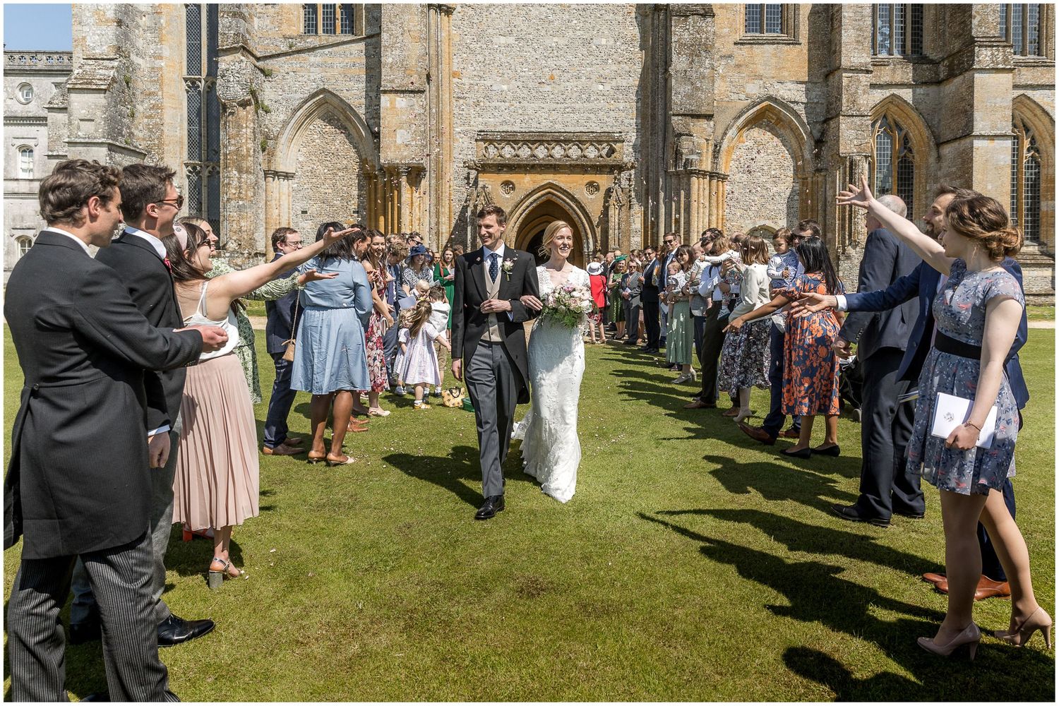 Wedding guests gather on the church lawn during an outdoor reception.