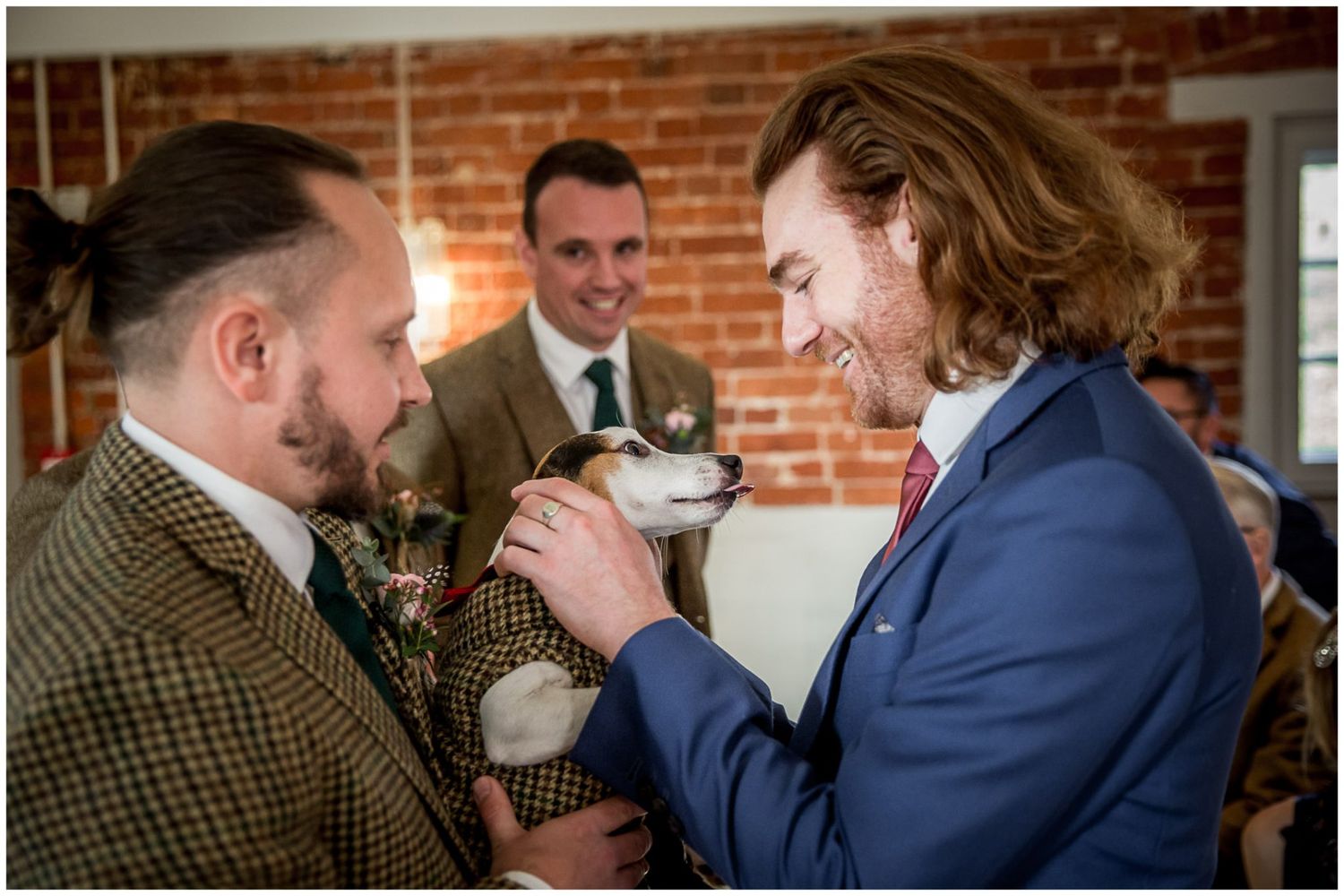 Wedding guests gathered in rustic brick venue during celebration.