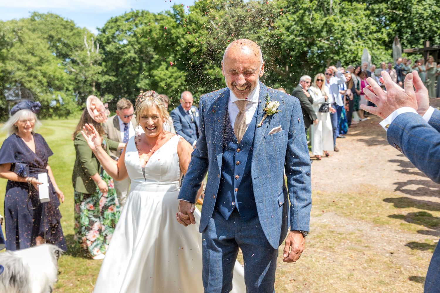 Outdoor wedding celebration with guests mingling on sunny lawn.