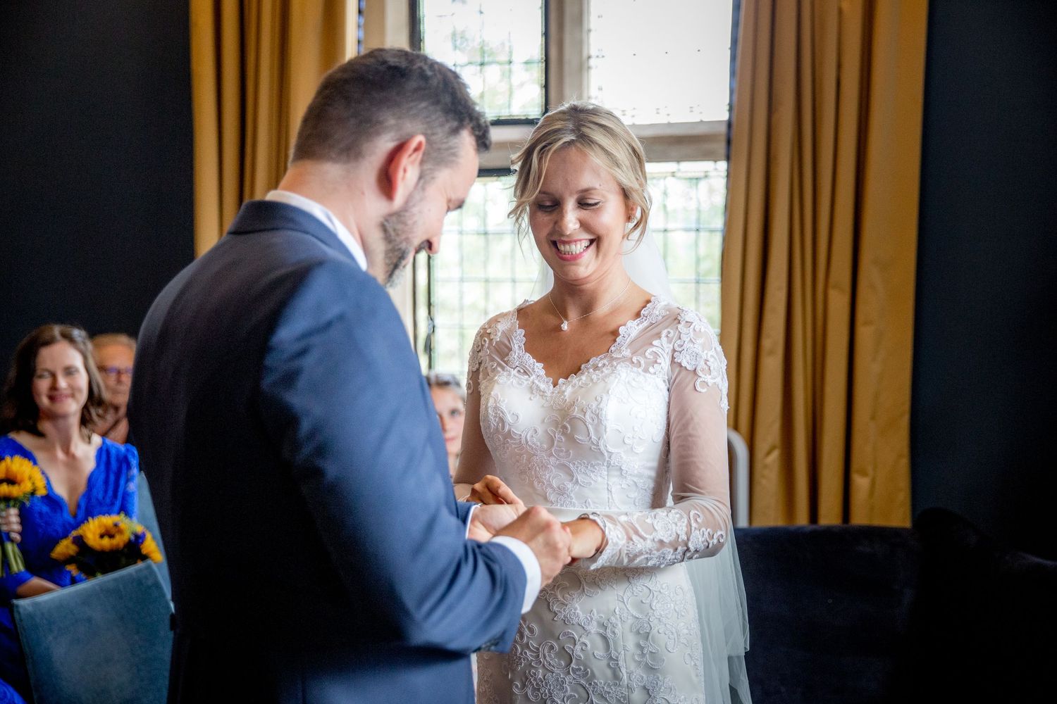 Intimate wedding moments captured by window light in elegant indoor setting.