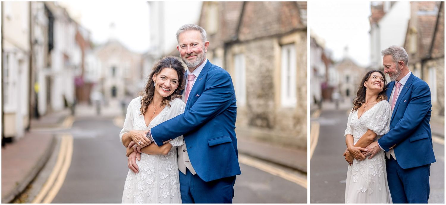 Wedding couple shares intimate moments along a quaint village street with traditional architecture.