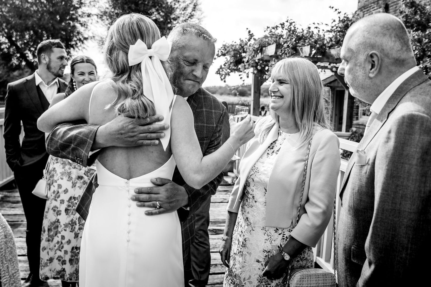 Black and white wedding celebration photos showing joyful moments between guests and loved ones during outdoor reception.