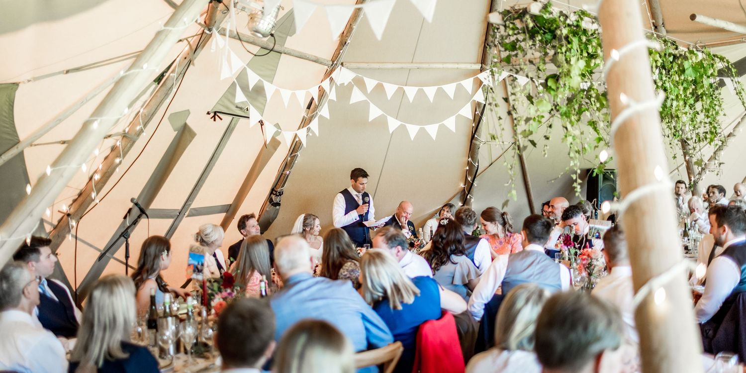 White bunting decorates an elegant wedding reception venue with natural lighting.