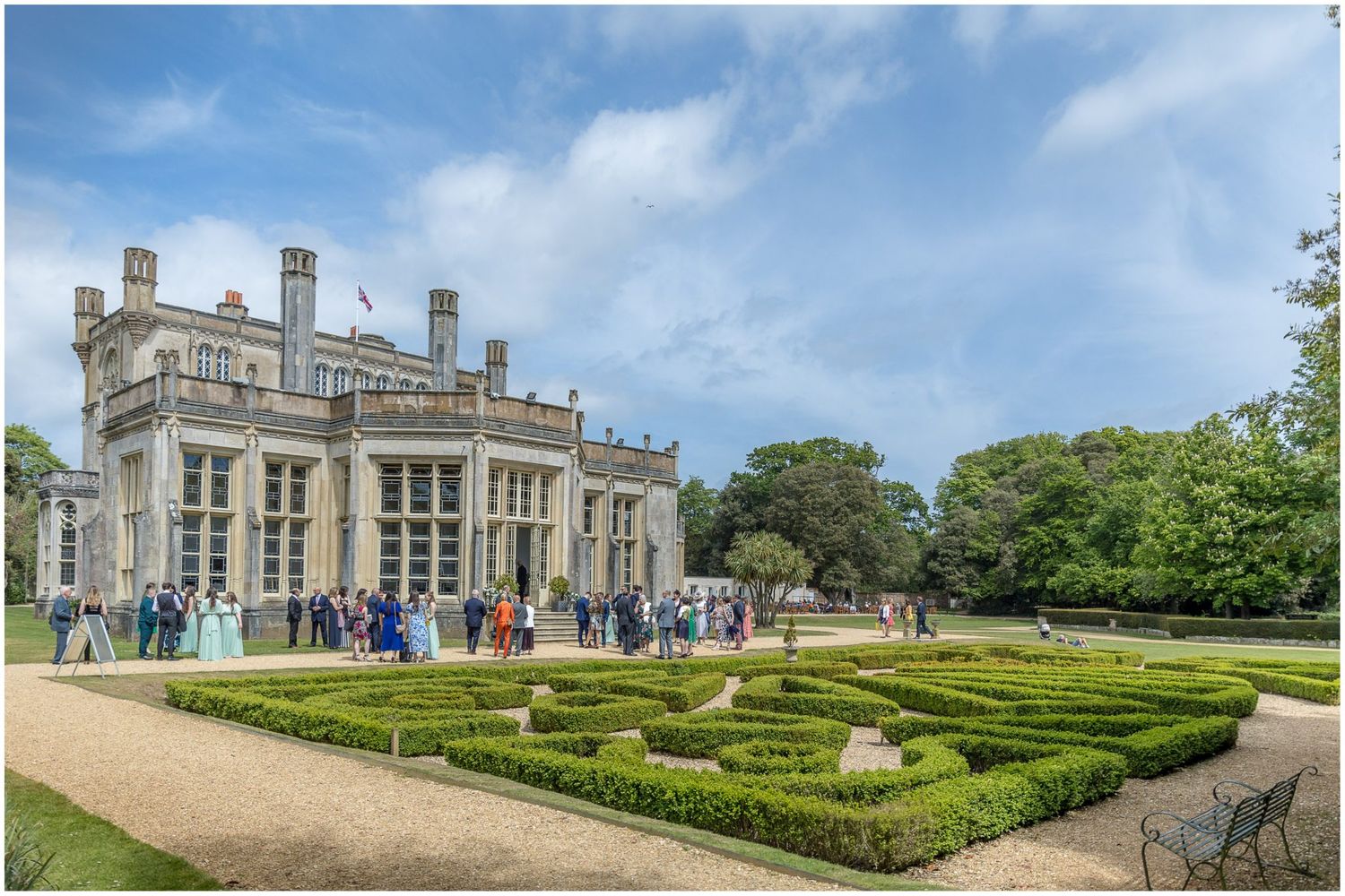 Historic mansion wedding venue with manicured gardens and grand architecture under blue skies.