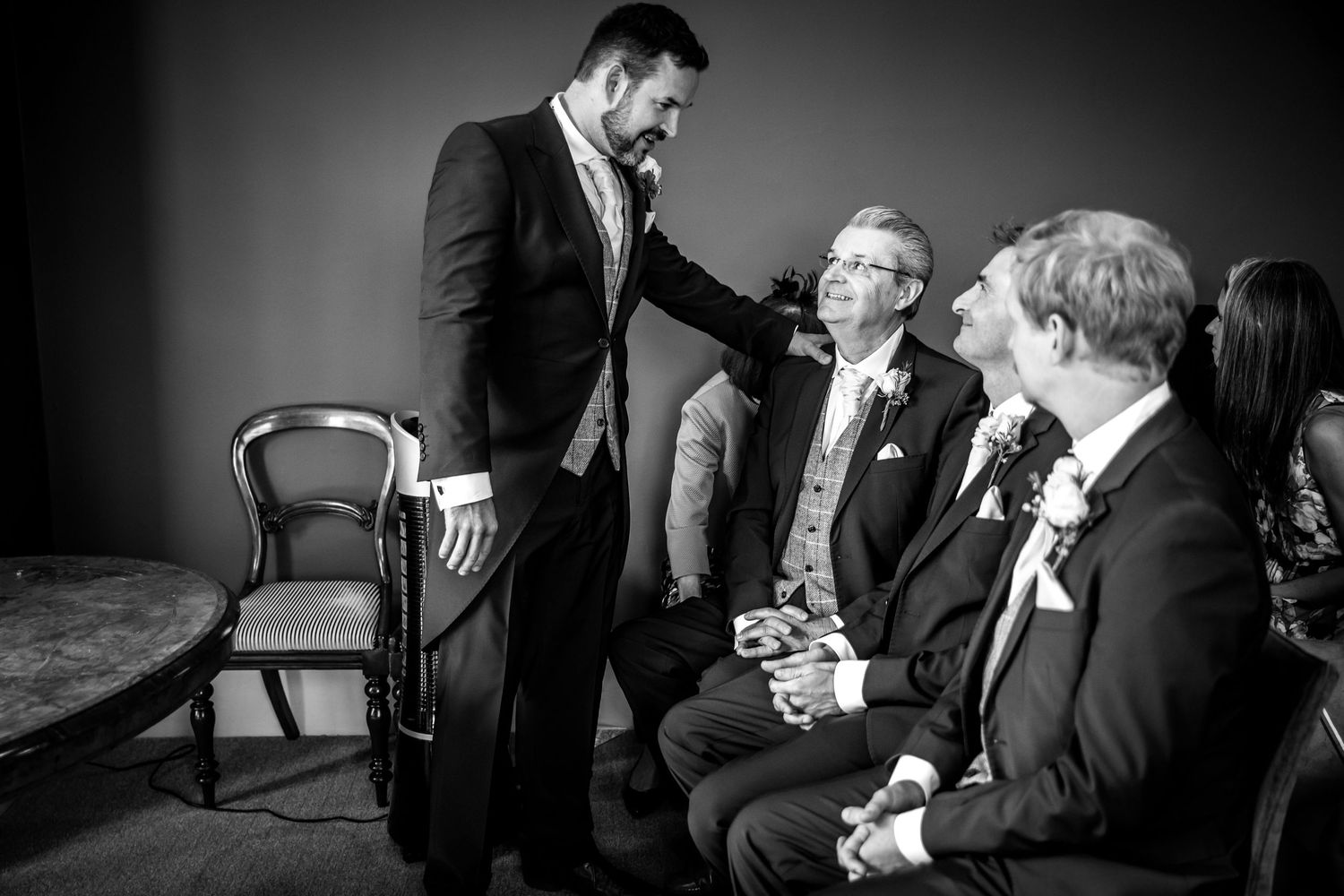 A black and white candid moment captured during wedding preparations.