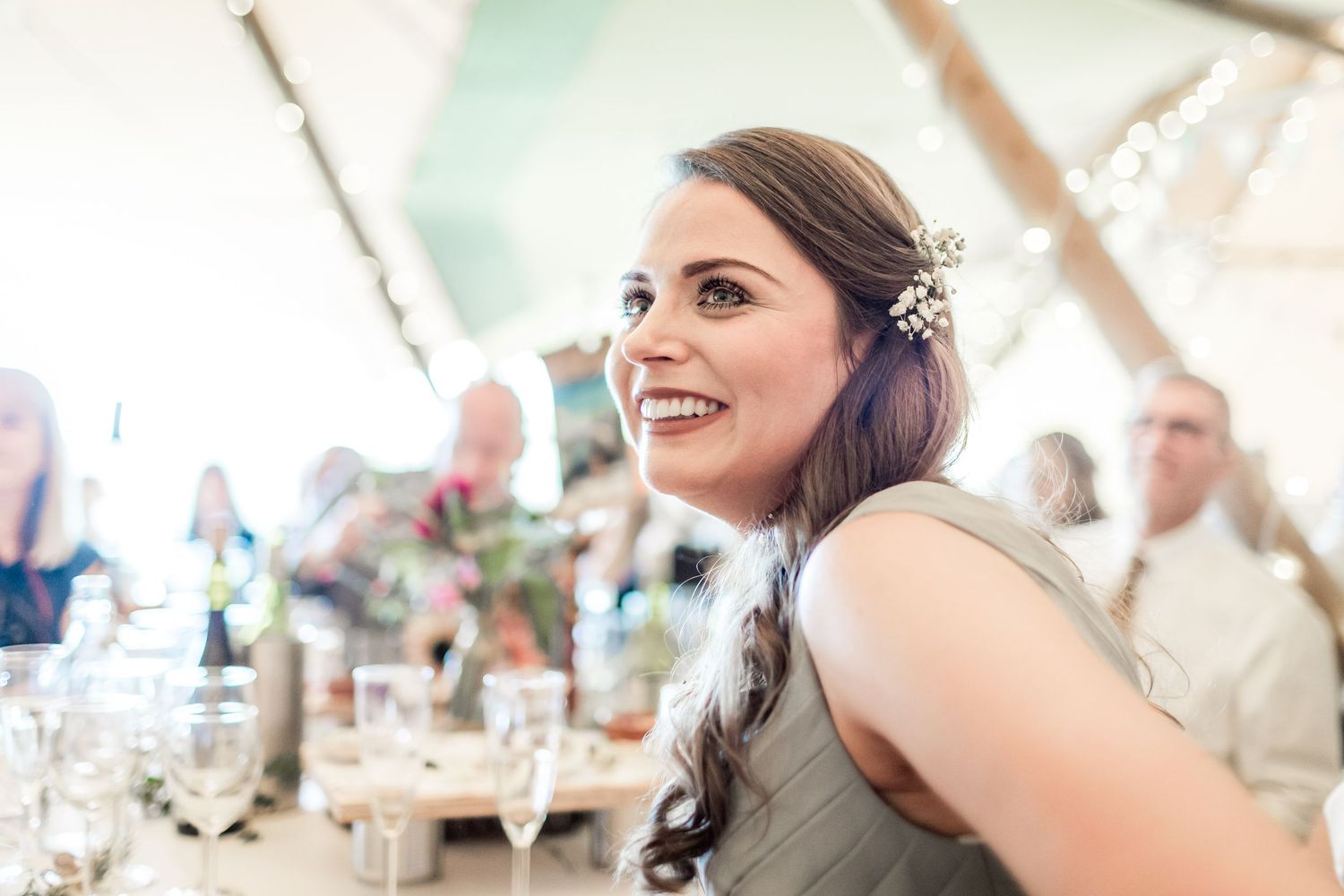 Wedding reception guests sharing joyful moments under decorative lighting.