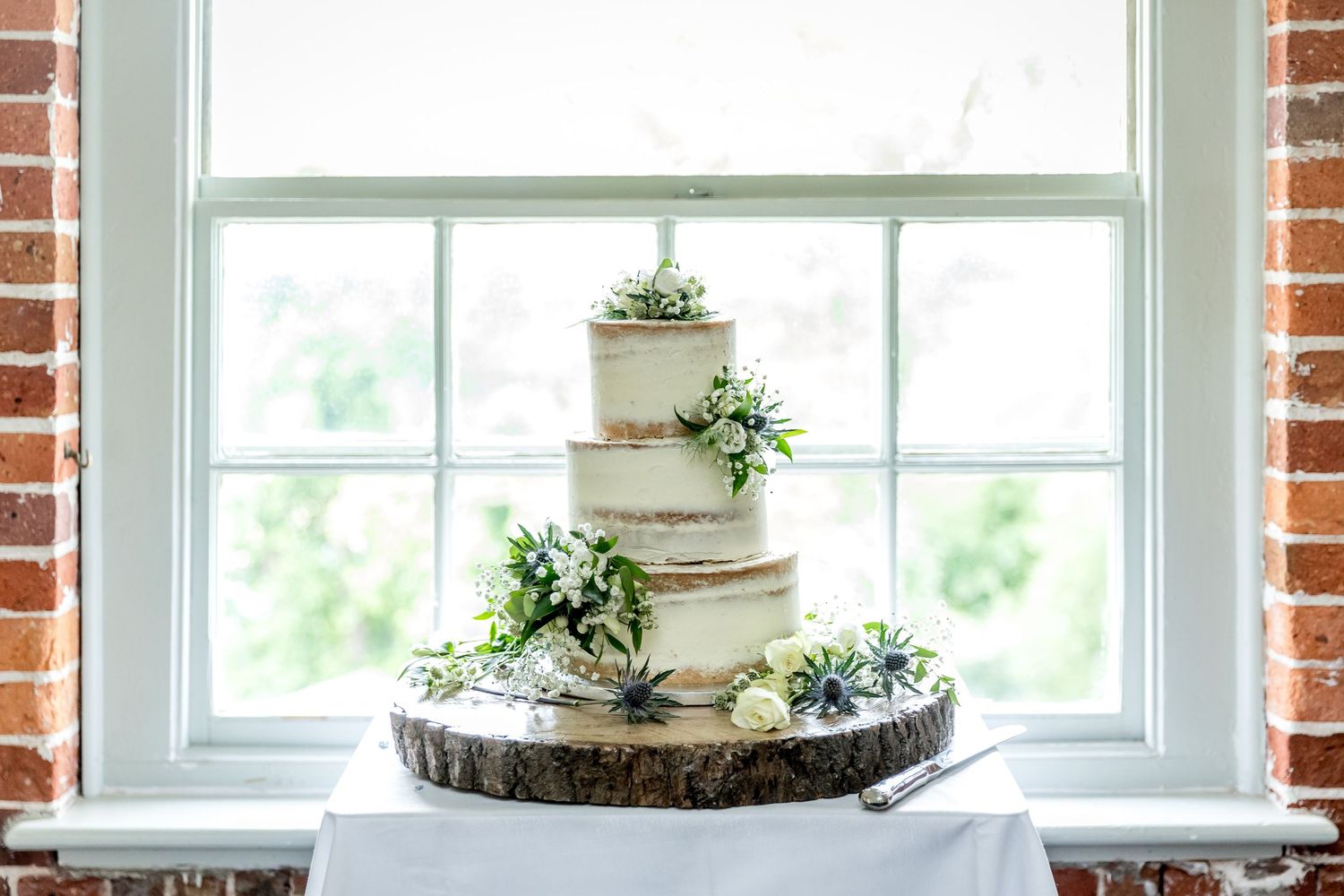 Bright windows with exposed brick walls create an airy atmosphere for wedding celebration.