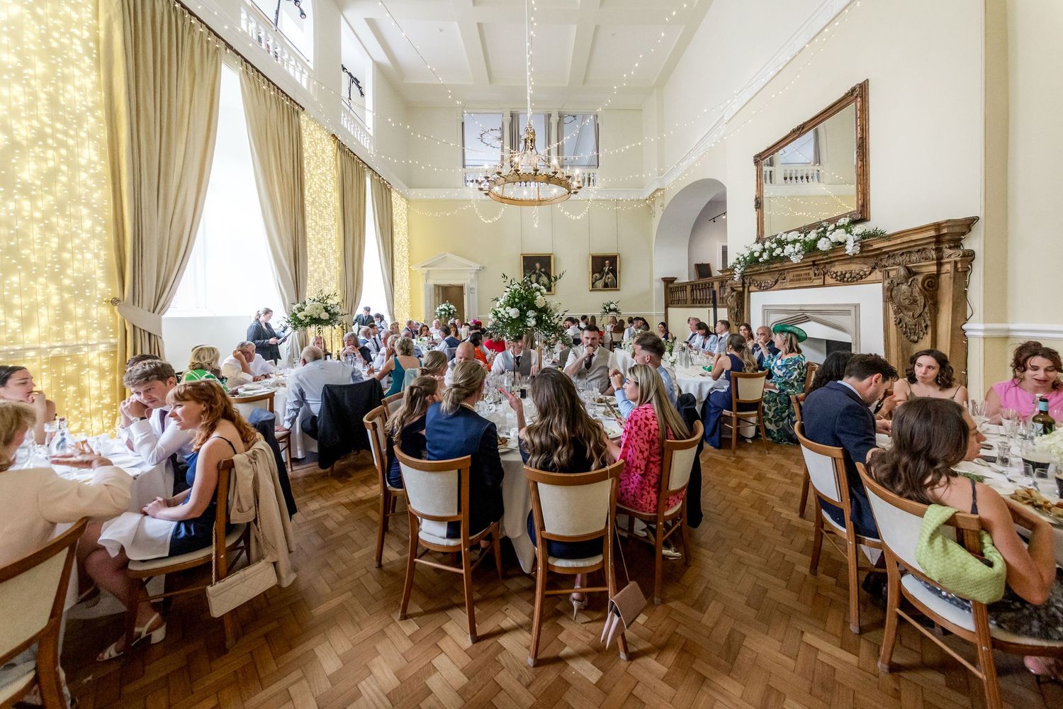 Panoramic view of a grand wedding reception hall with elegant table settings and classic decor.