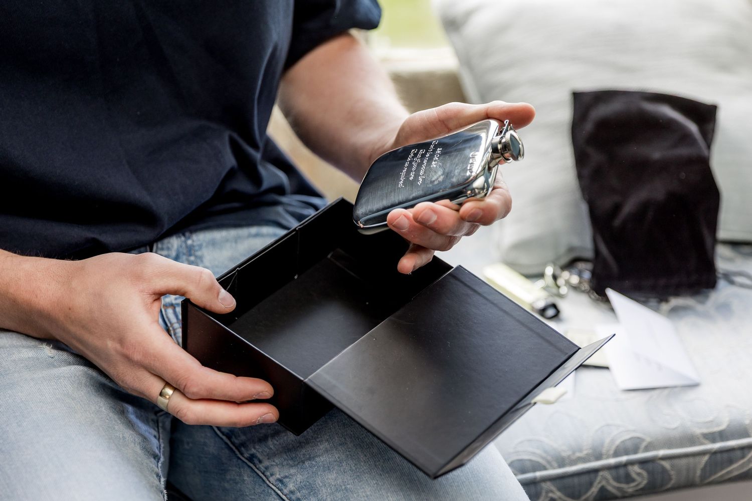 Hands holding open wallet and examining contents while seated.