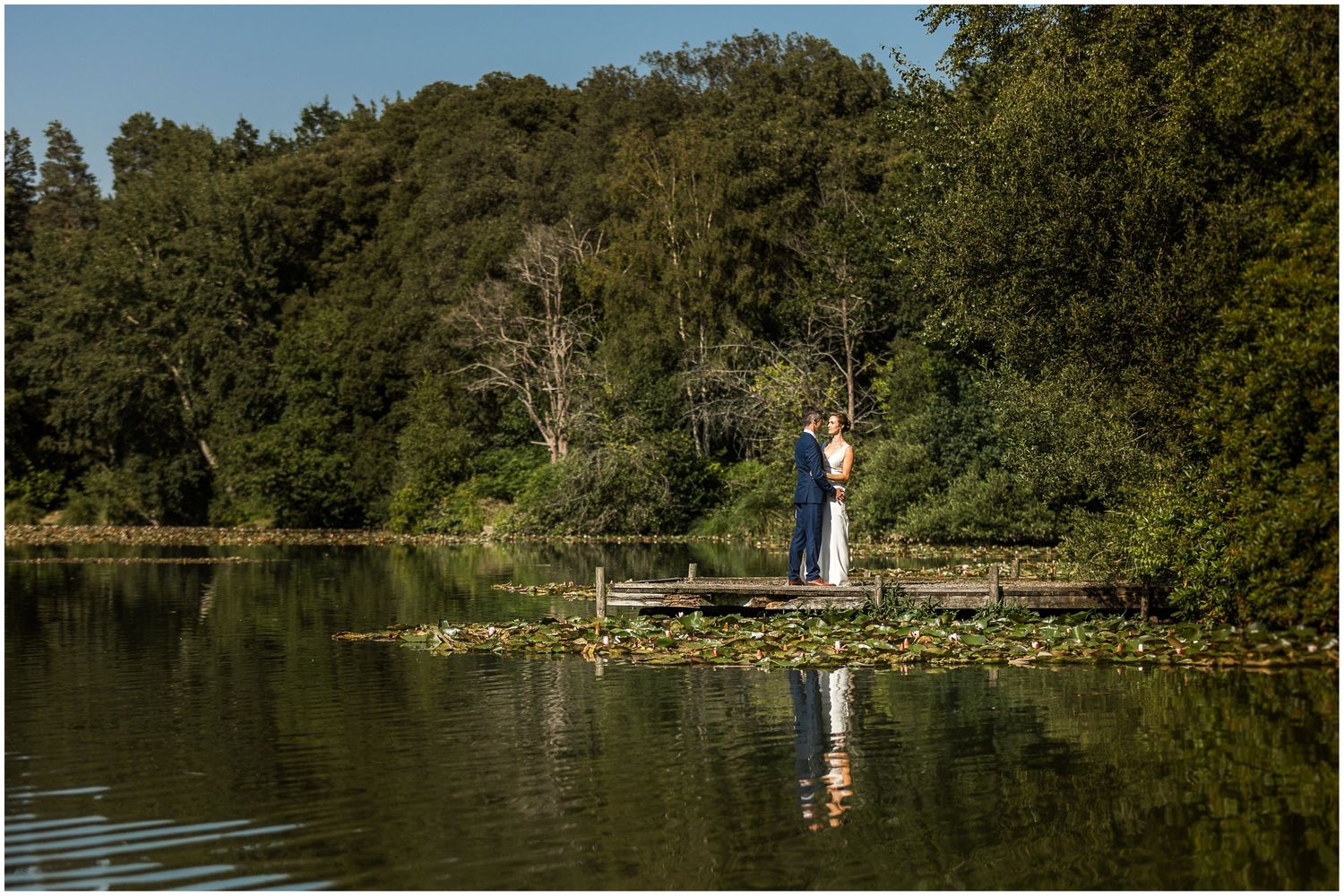 Wedding photography couple portrait by a lake in the grounds of Walhampton School in the New Forest