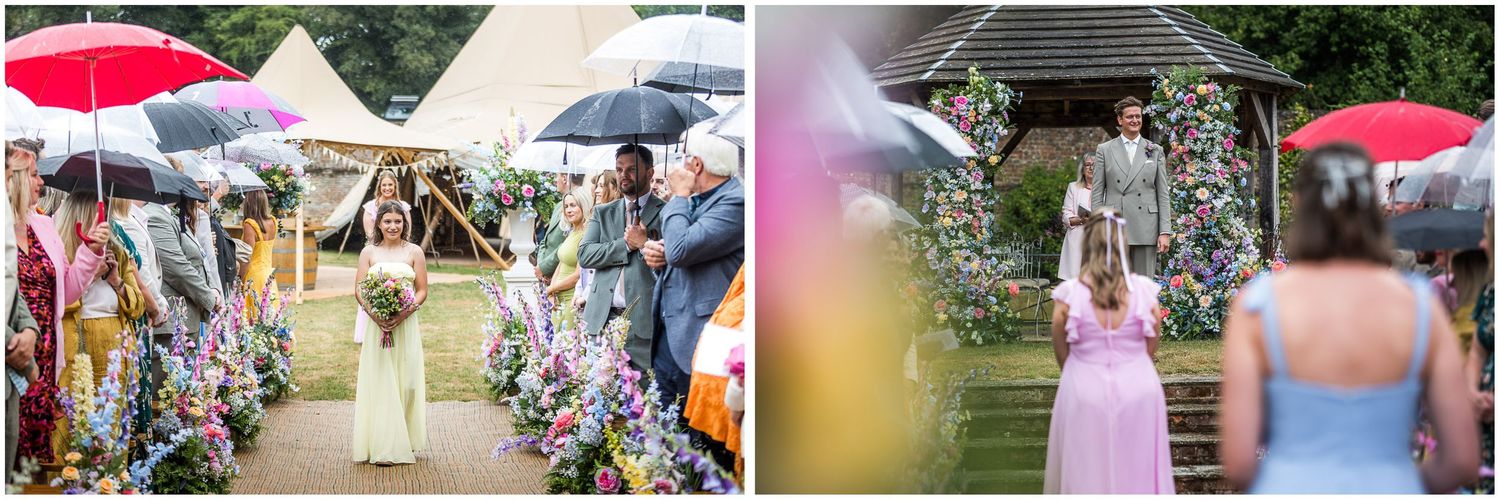 Bridesmaids walk down the aisle set up with floral decorations at the Holywell Estate in Hampshire
