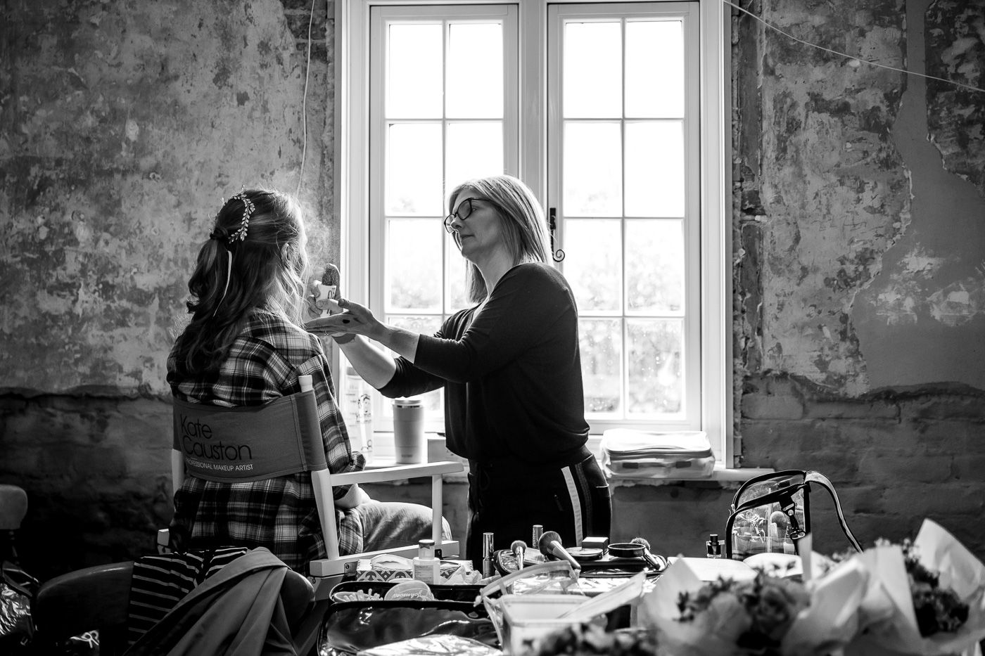 Black and white photos of wedding preparation in a rustic room with natural window light.