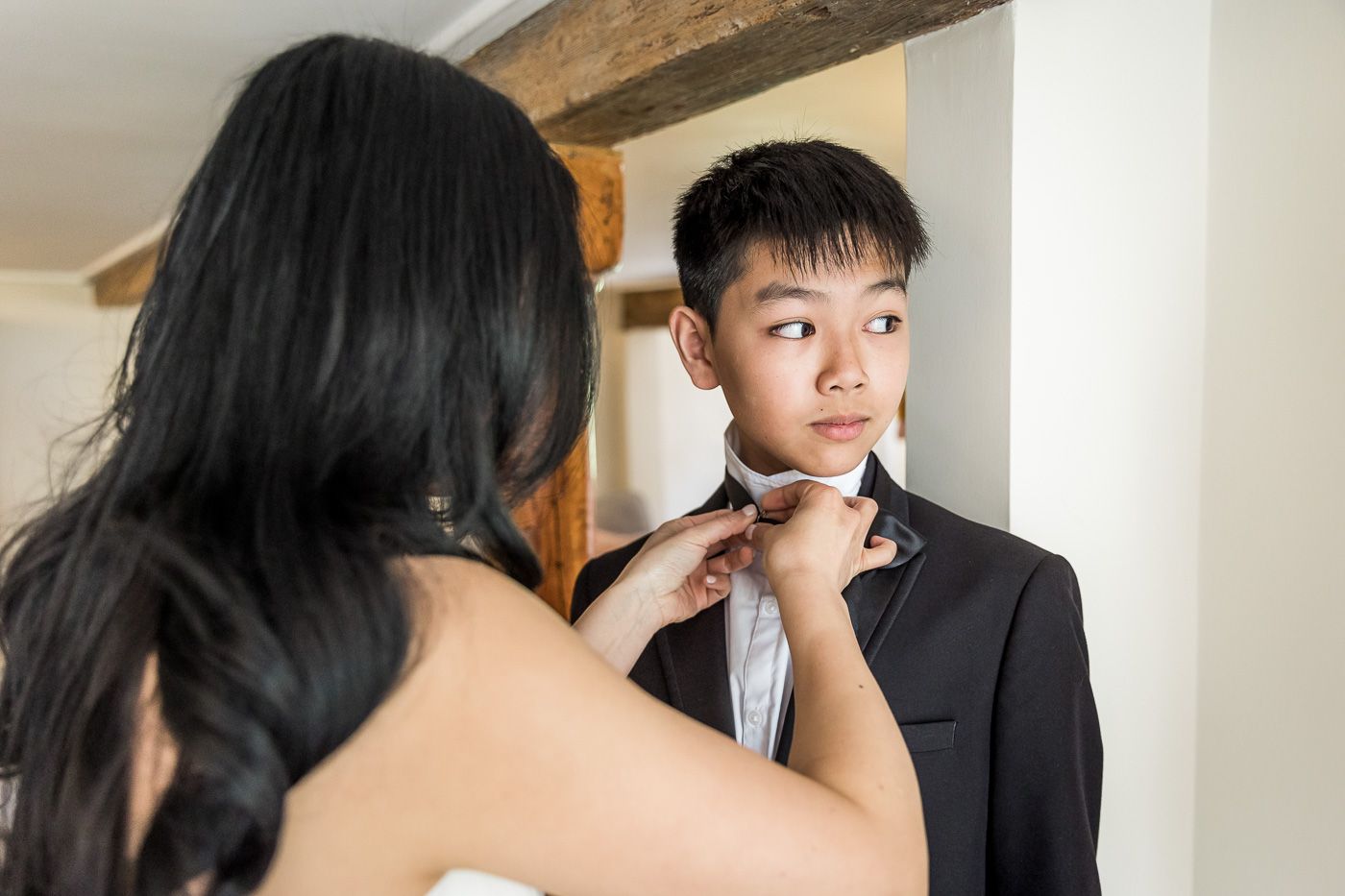 A close-up moment of wedding preparation as a tie is being adjusted.