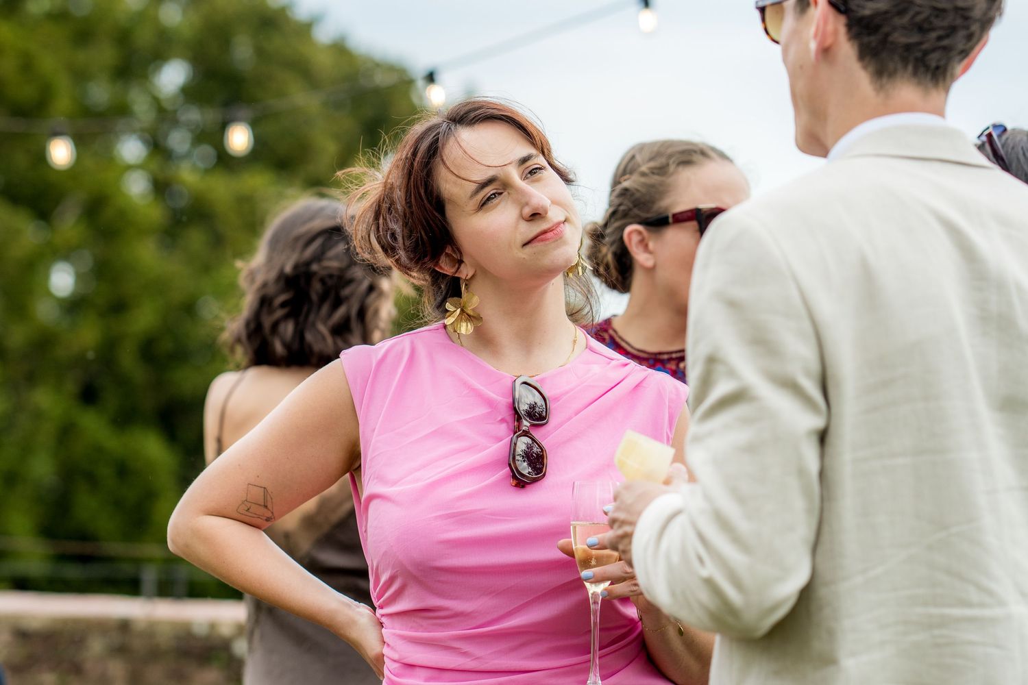 Wedding guests enjoying drinks and conversation at an outdoor garden reception.