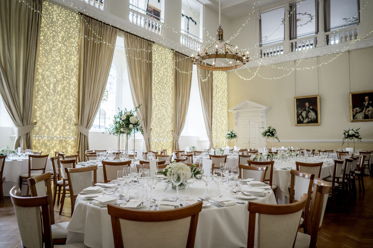 Panoramic view of luxurious wedding reception room with classic decor and formal table settings.