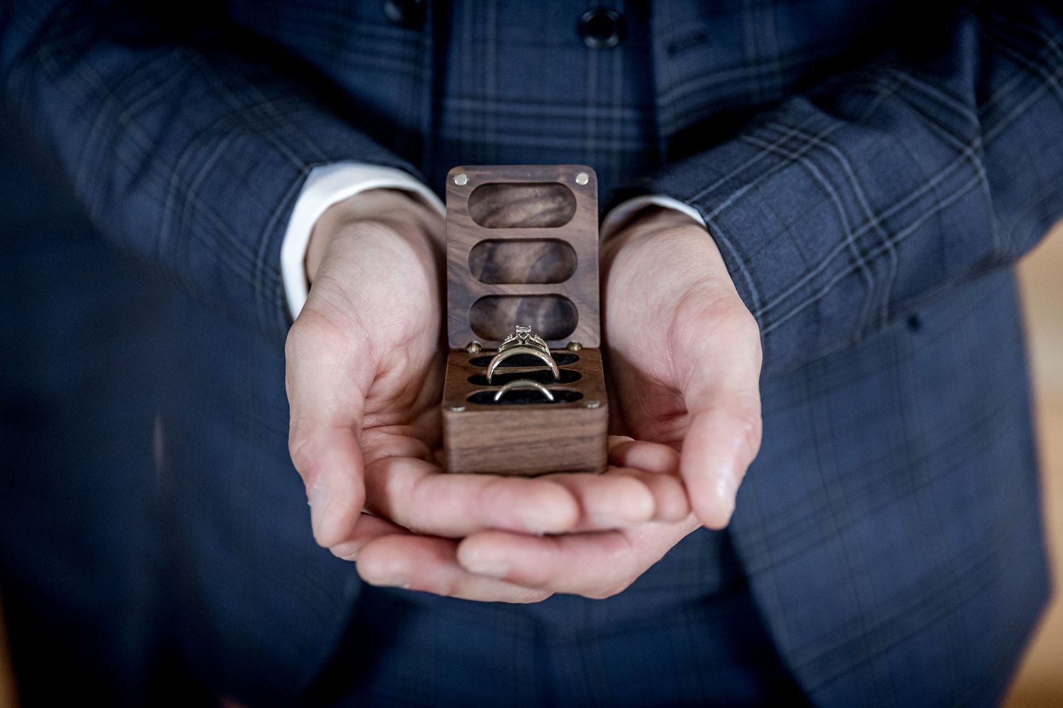 Close-up shots of wedding rings displayed on dark surfaces with elegant details.