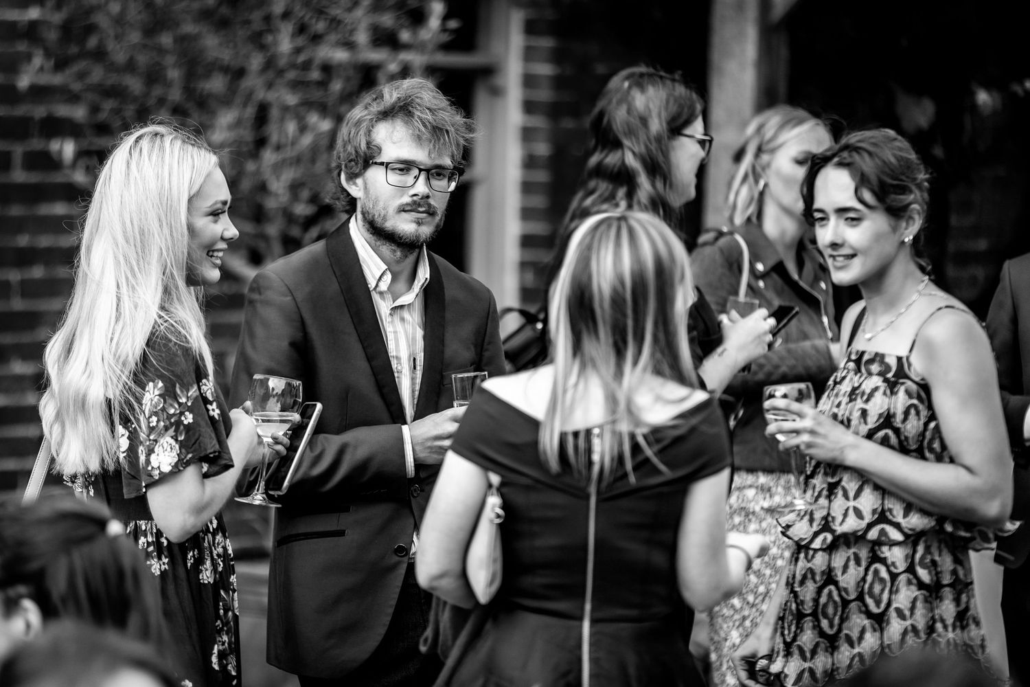 Wedding guests mingle and socialize during an outdoor reception celebration.