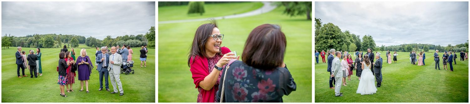 Wedding guests scattered across a vast lawn during an afternoon garden celebration.