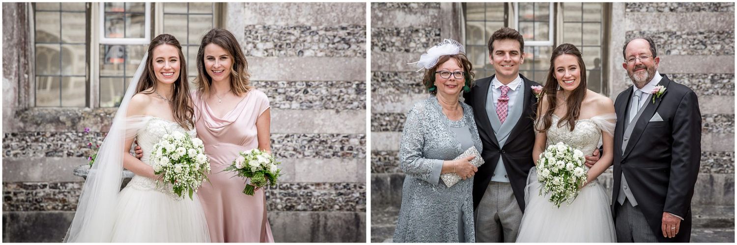 Wedding party poses together against rustic stone wall backdrop with floral bouquets.