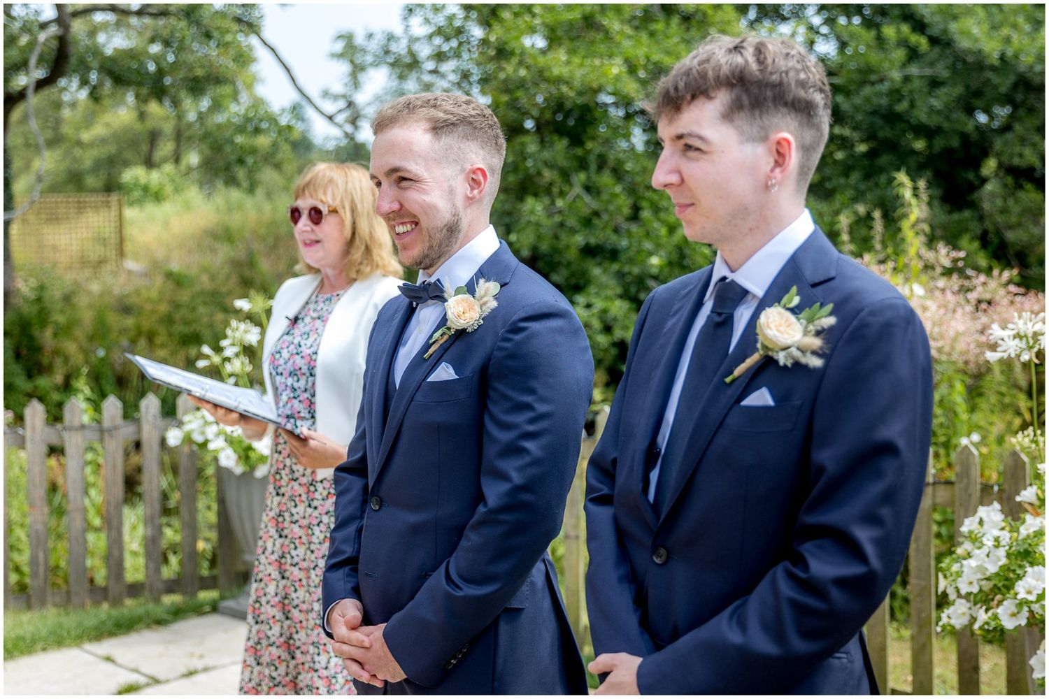 Groomsmen in navy suits share candid moments before the ceremony.