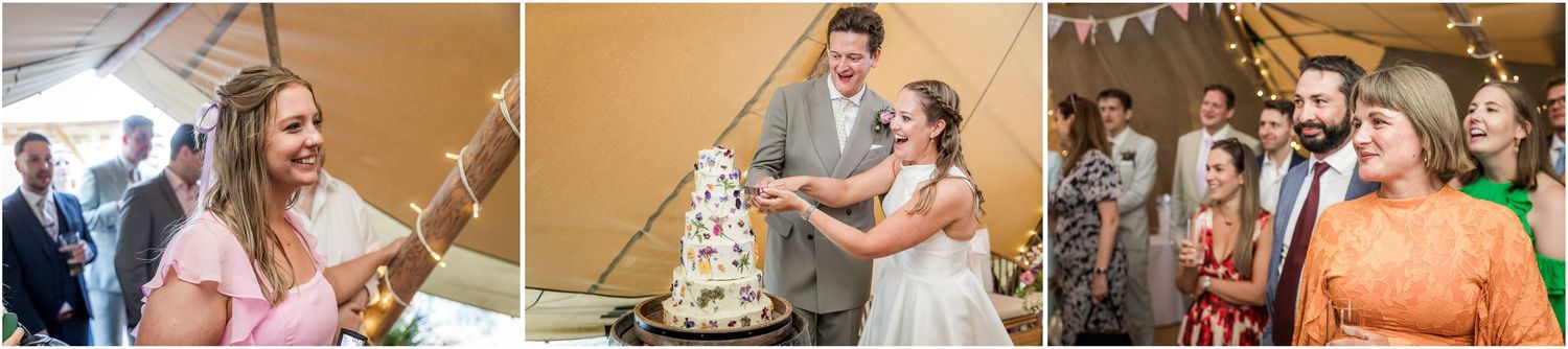 Wedding guests watch smiling as the bride and groom cut the wedding cake inside the marquee wedding reception venue