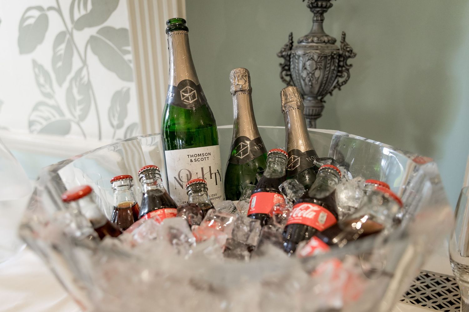 Champagne bottles chilling in an ornate silver ice bucket.