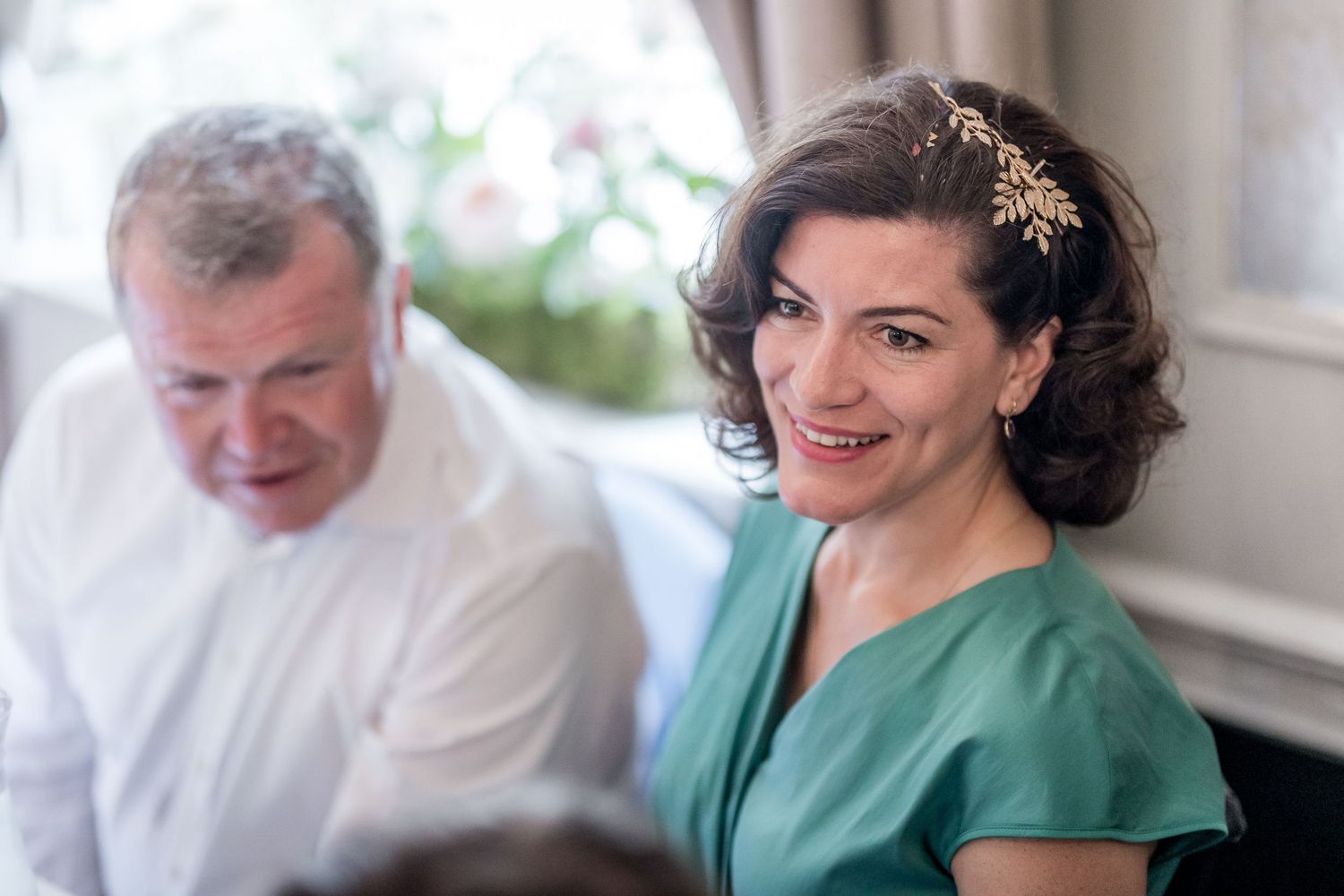 Guests share warm smiles and laughter during a wedding reception celebration.